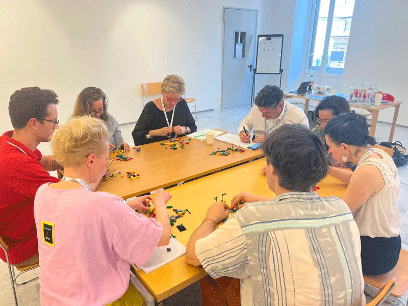 A person holding a LEGO model, symbolizing individual creation and insight.