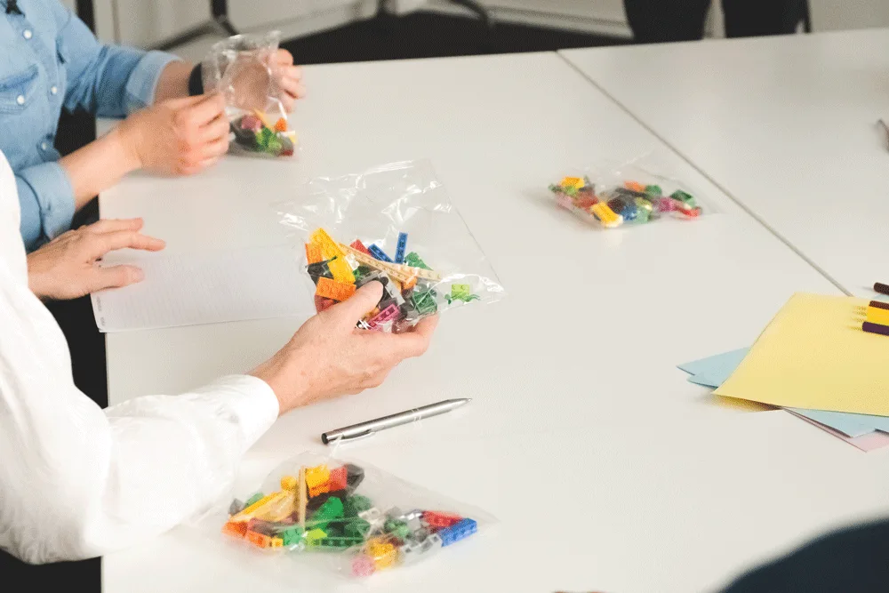 Hands engaged in building a LEGO model, representing a state of flow.
